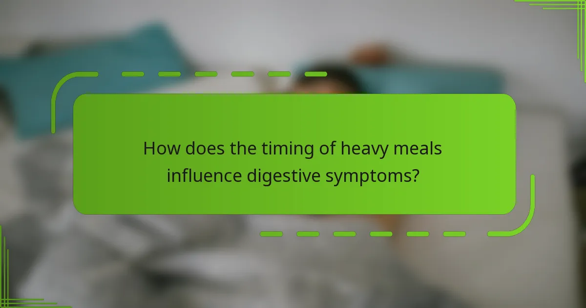 How does the timing of heavy meals influence digestive symptoms?